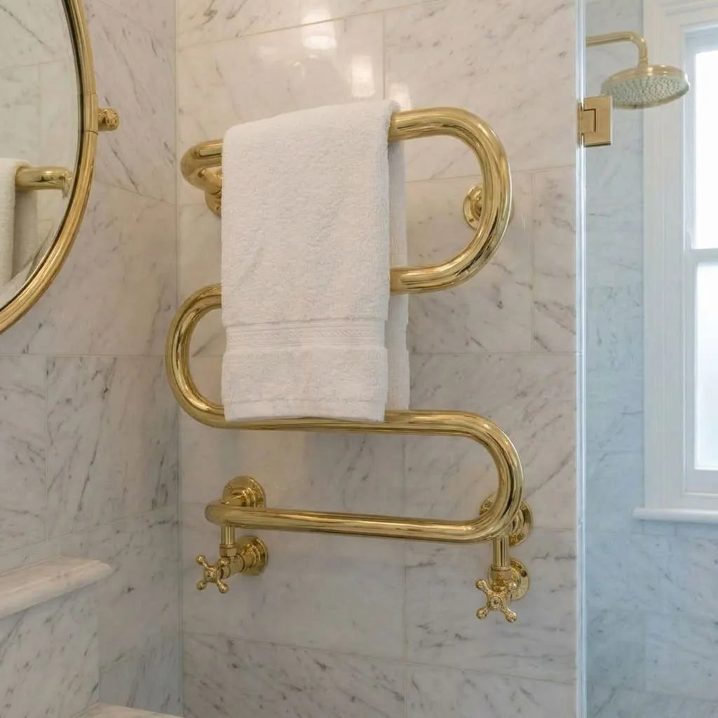 Wall-mounted serpentine brass towel radiator with polished living finish and traditional valves
