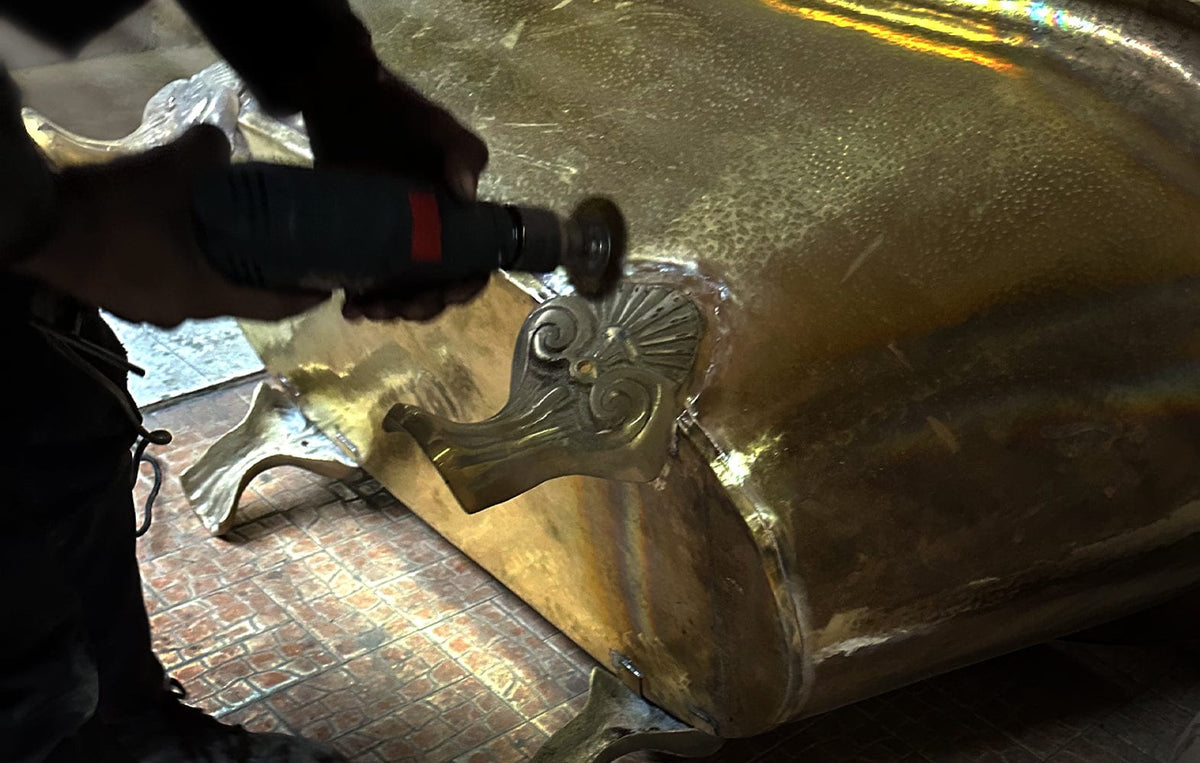 Hand-finishing a brass bathtub foot in the Zayian workshop