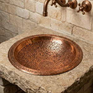 Handcrafted copper bathroom vessel sink with decorative engraving and brass fixtures