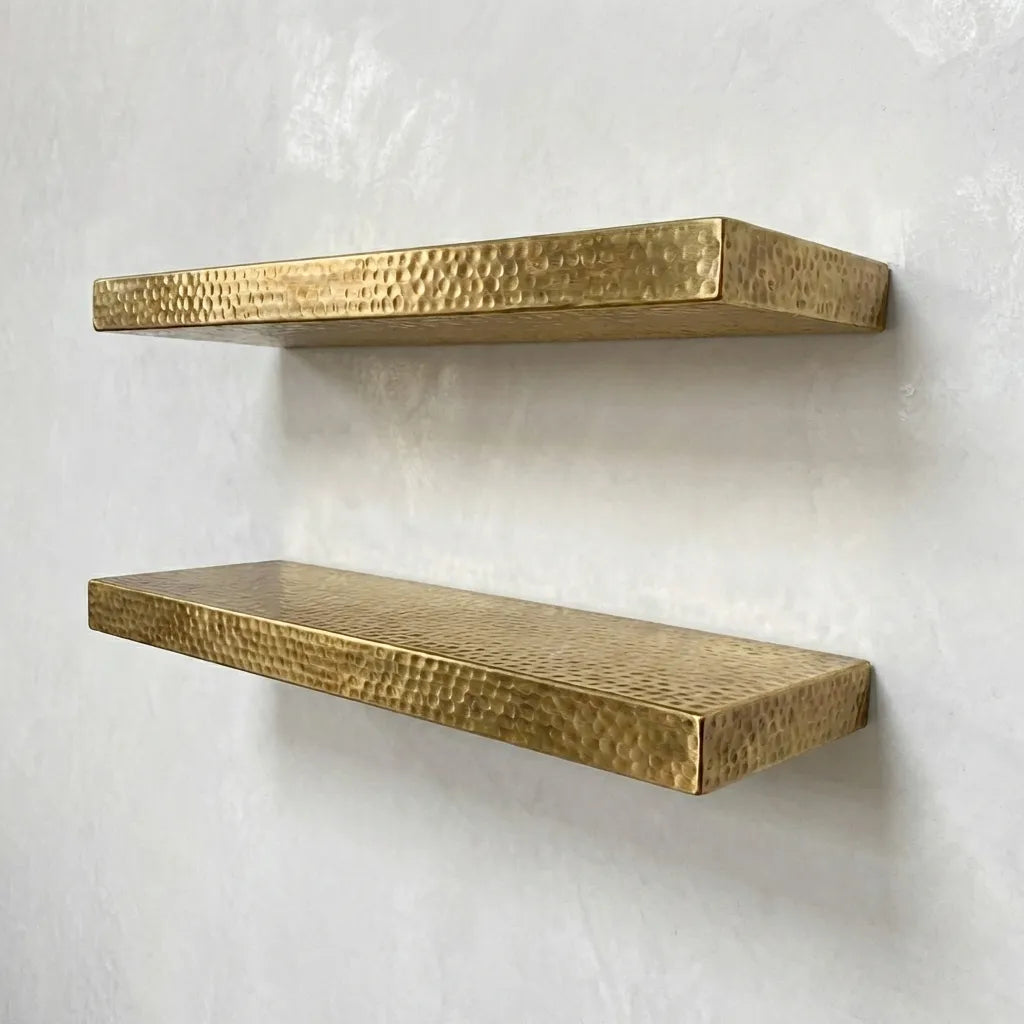 Handmade hammered brass floating shelves mounted on plaster wall, minimalist styling