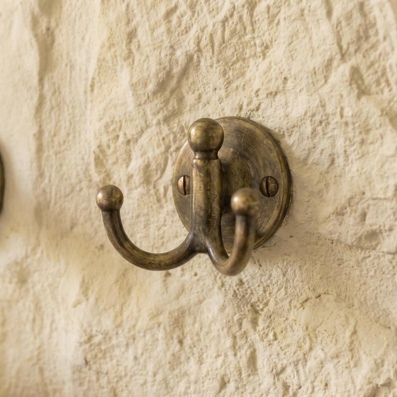The hook is a solid antique brass double robe hook. The doc includes: