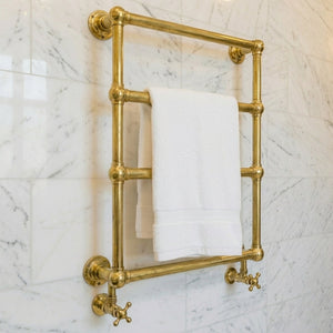 Gold towel rack with a white towel on a marble wall