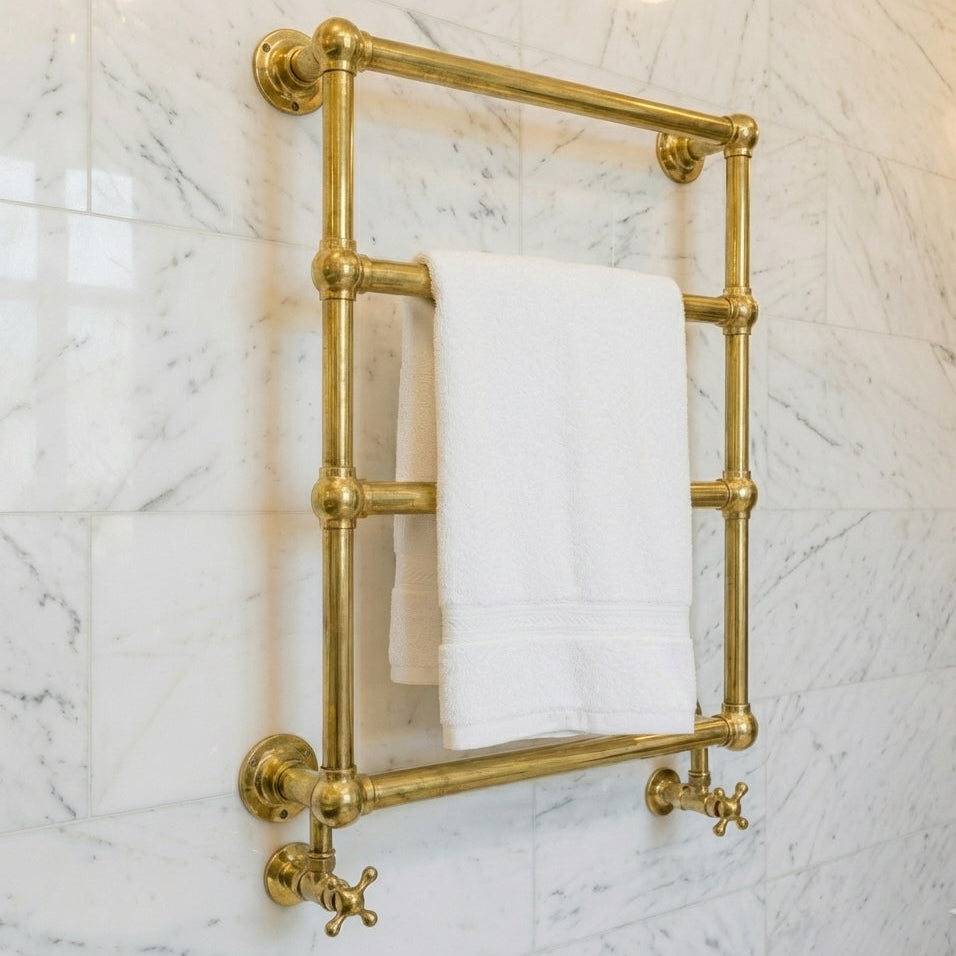 Gold towel rack with a white towel on a marble wall
