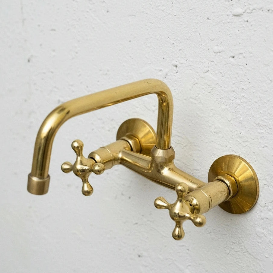Gold faucet on a white textured wall