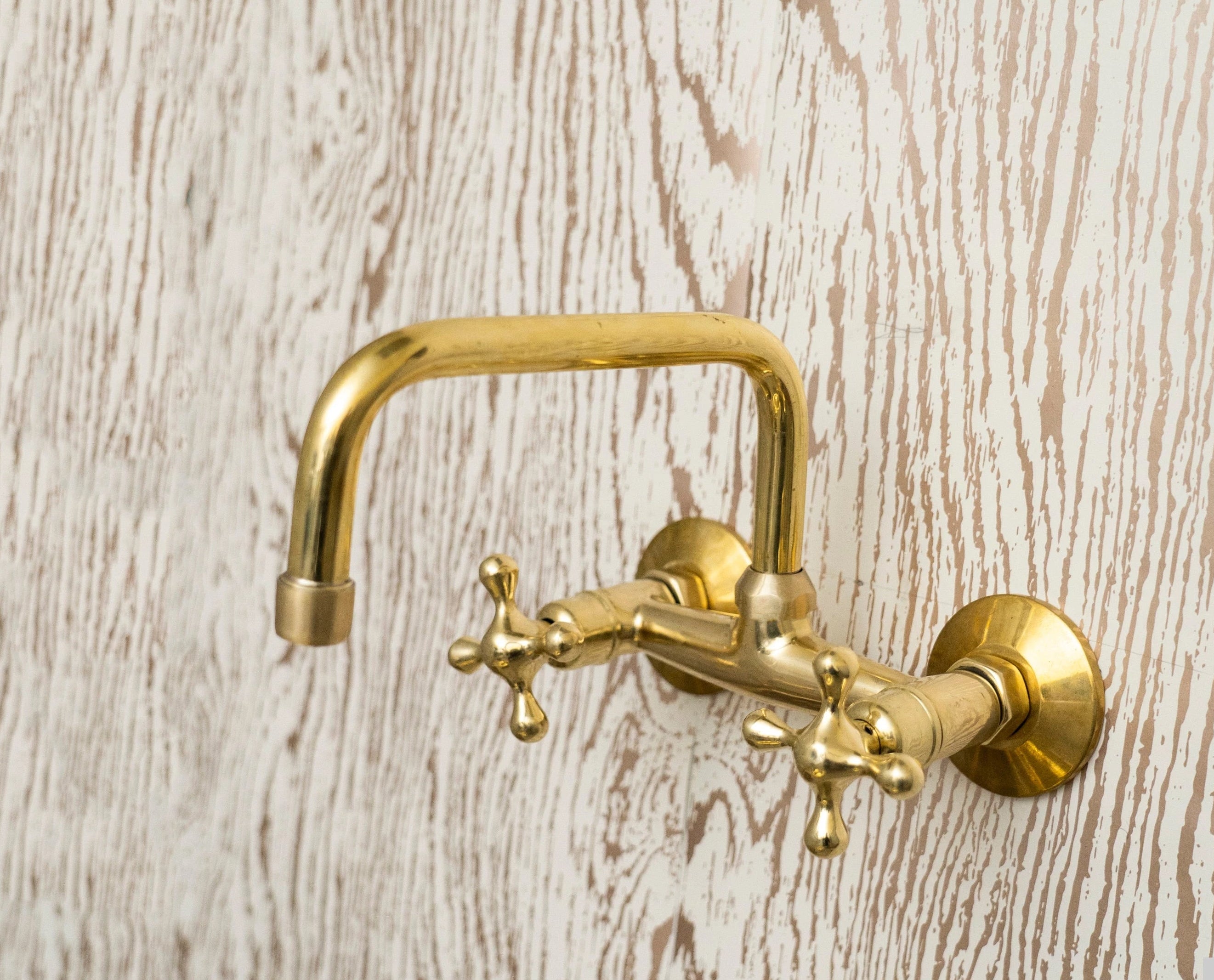 Gold faucet on a wooden wall