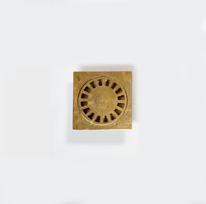 Hammered unlacquered brass square shower drain with removable round cover