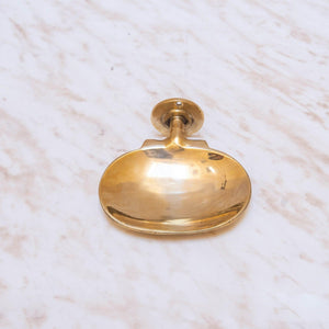 Front view of a handmade brass wall-mounted oval soap dish