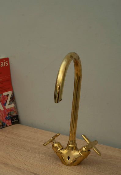 Handmade unlacquered brass gooseneck faucet with two cross handles shown standing