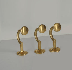 Set of three vintage unlacquered brass wall coat hooks with round ends