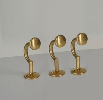 Set of three vintage unlacquered brass wall coat hooks with round ends