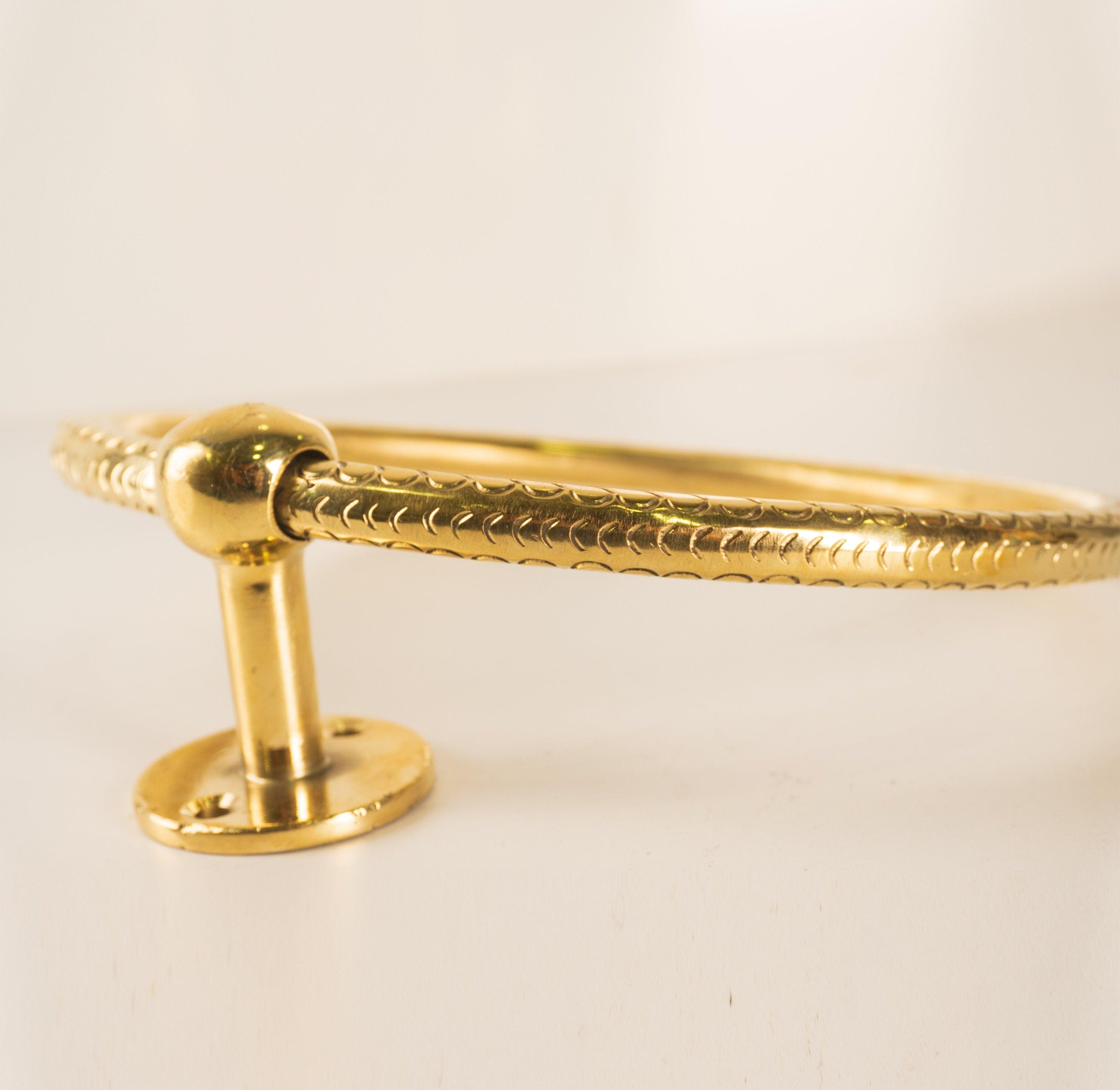 Side detail of a solid brass bathroom towel ring with round mounting plate