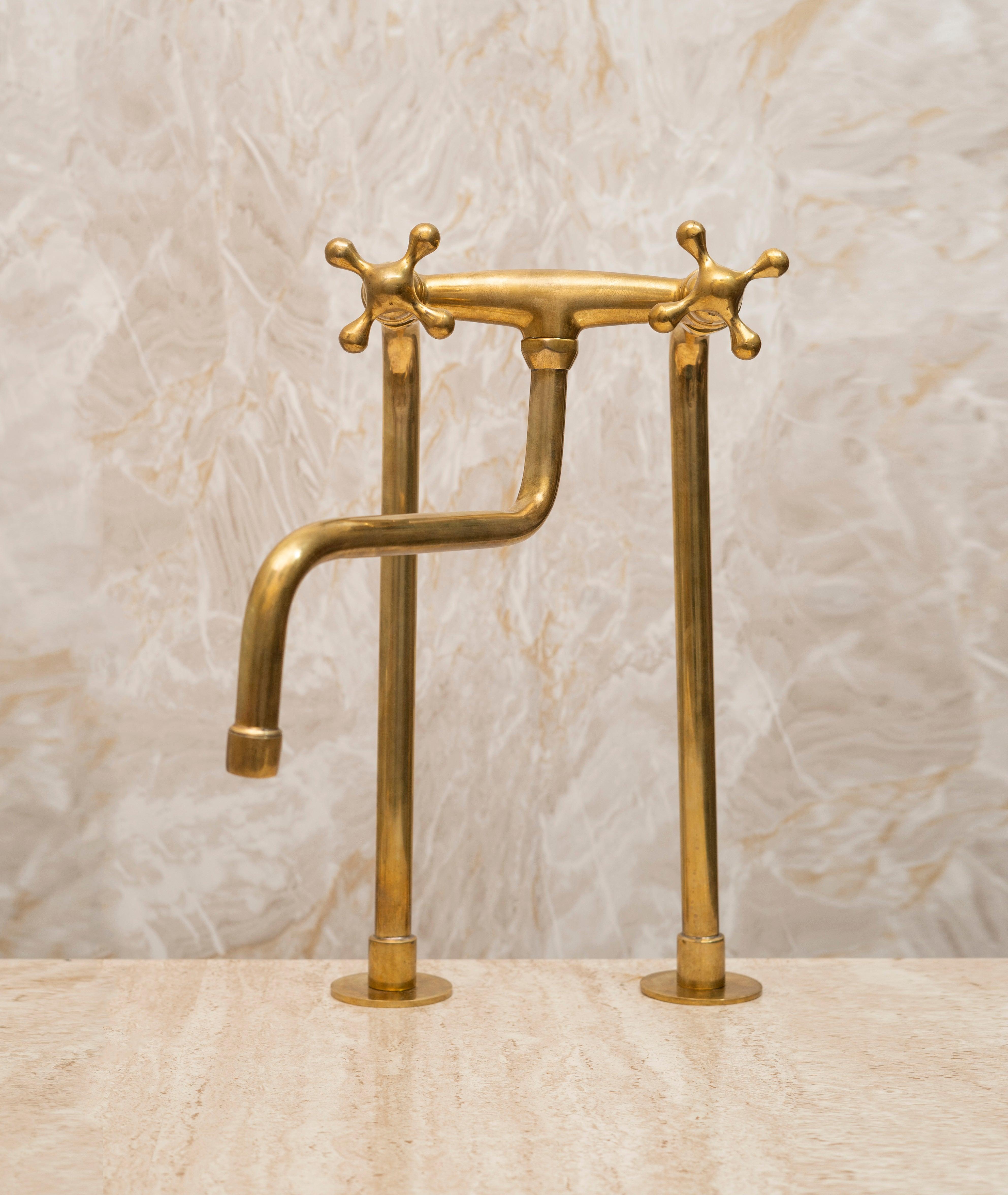 Tall unlacquered brass bridge kitchen faucet with cross handles for a farmhouse sink