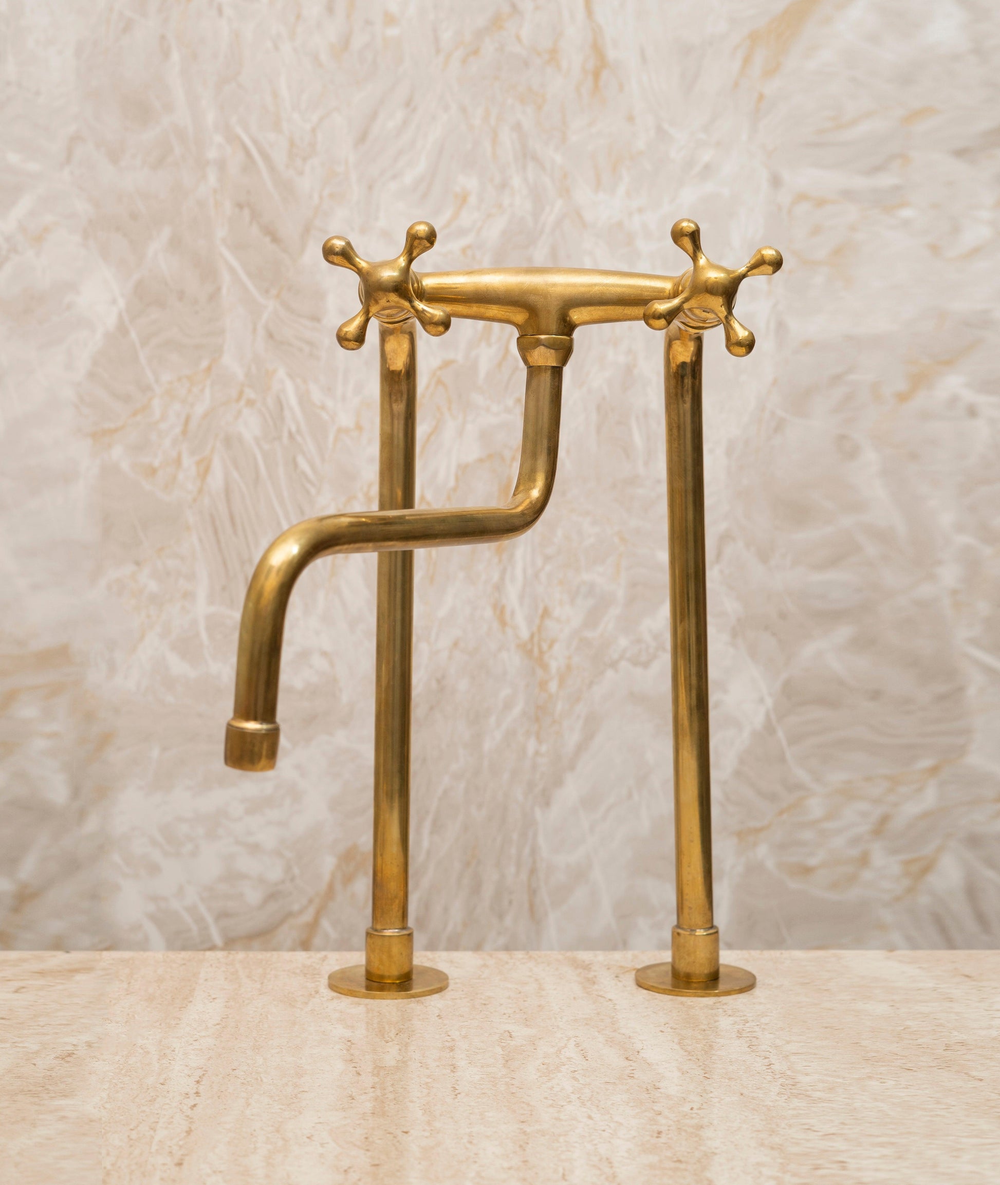 Tall unlacquered brass bridge kitchen faucet with cross handles for a farmhouse sink