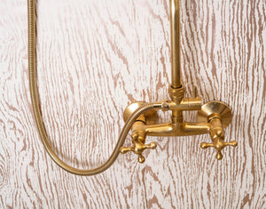 Unlacquered brass exposed shower mixer with cross handles and handheld shower hose