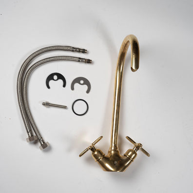 Top view of an unlacquered brass gooseneck sink faucet and installation components