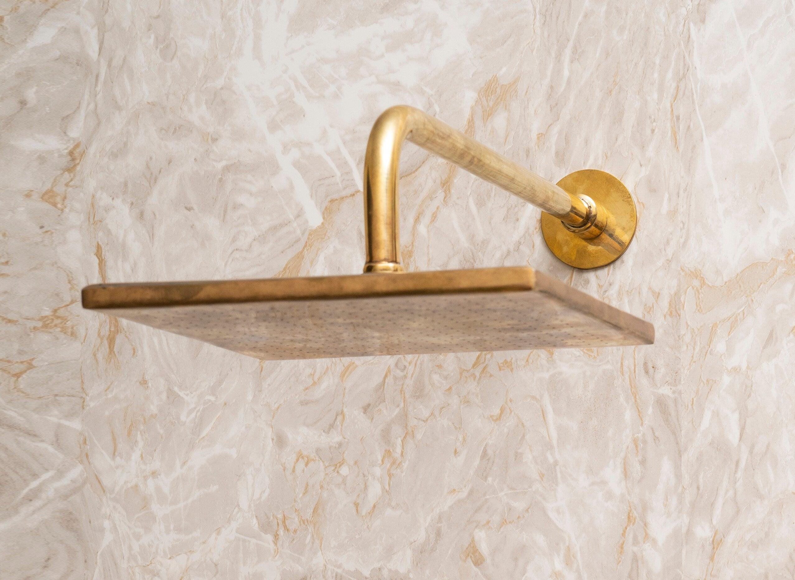 Unlacquered brass square rain shower head with wall-mounted shower arm