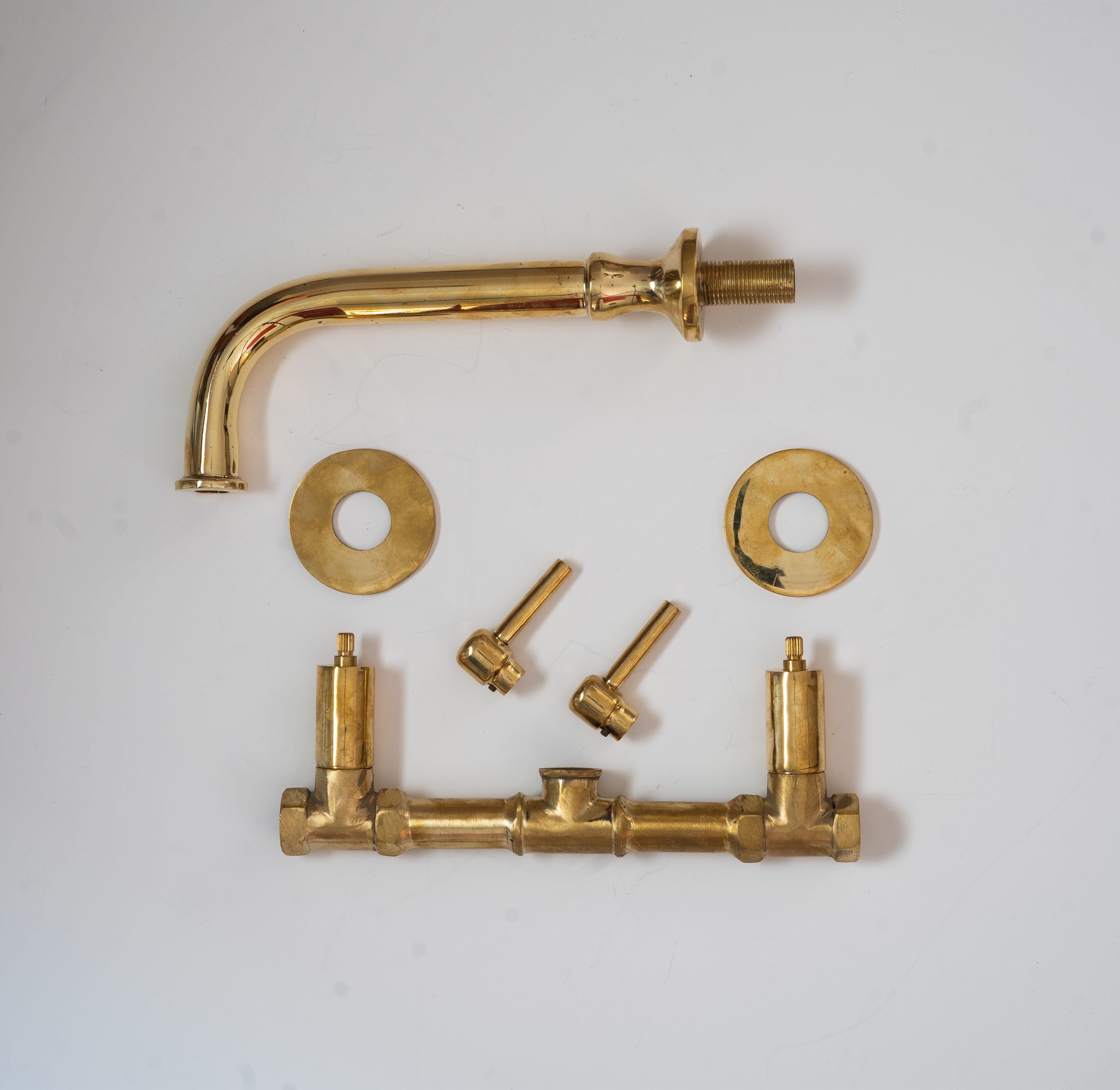 Unlacquered brass wall-mounted bathroom faucet parts with curved spout and cross handles