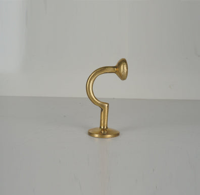 Profile view of a vintage unlacquered brass wall hook with curved stem